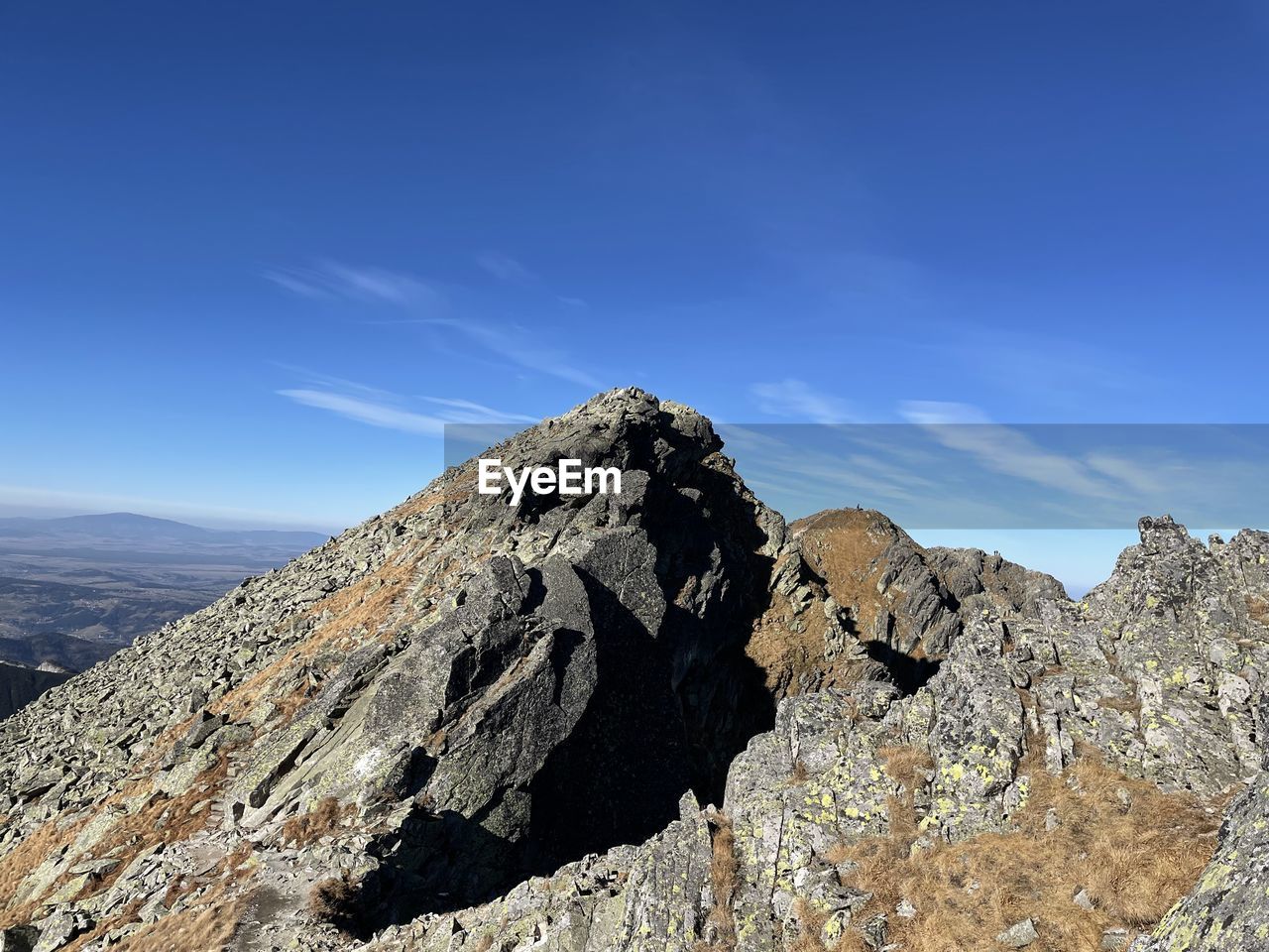 Rock formation on mountain against blue sky