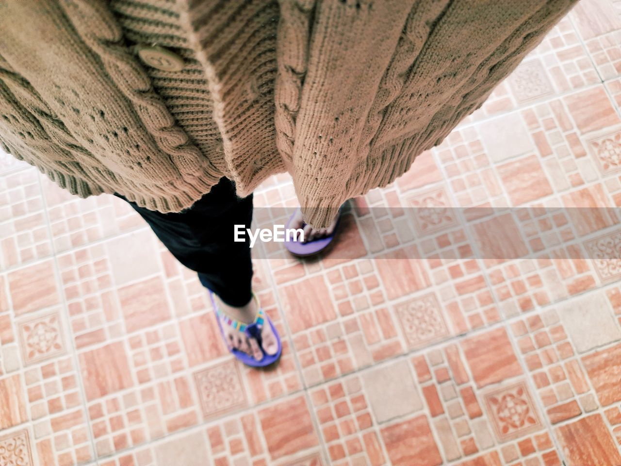 Low section of people walking on tiled floor