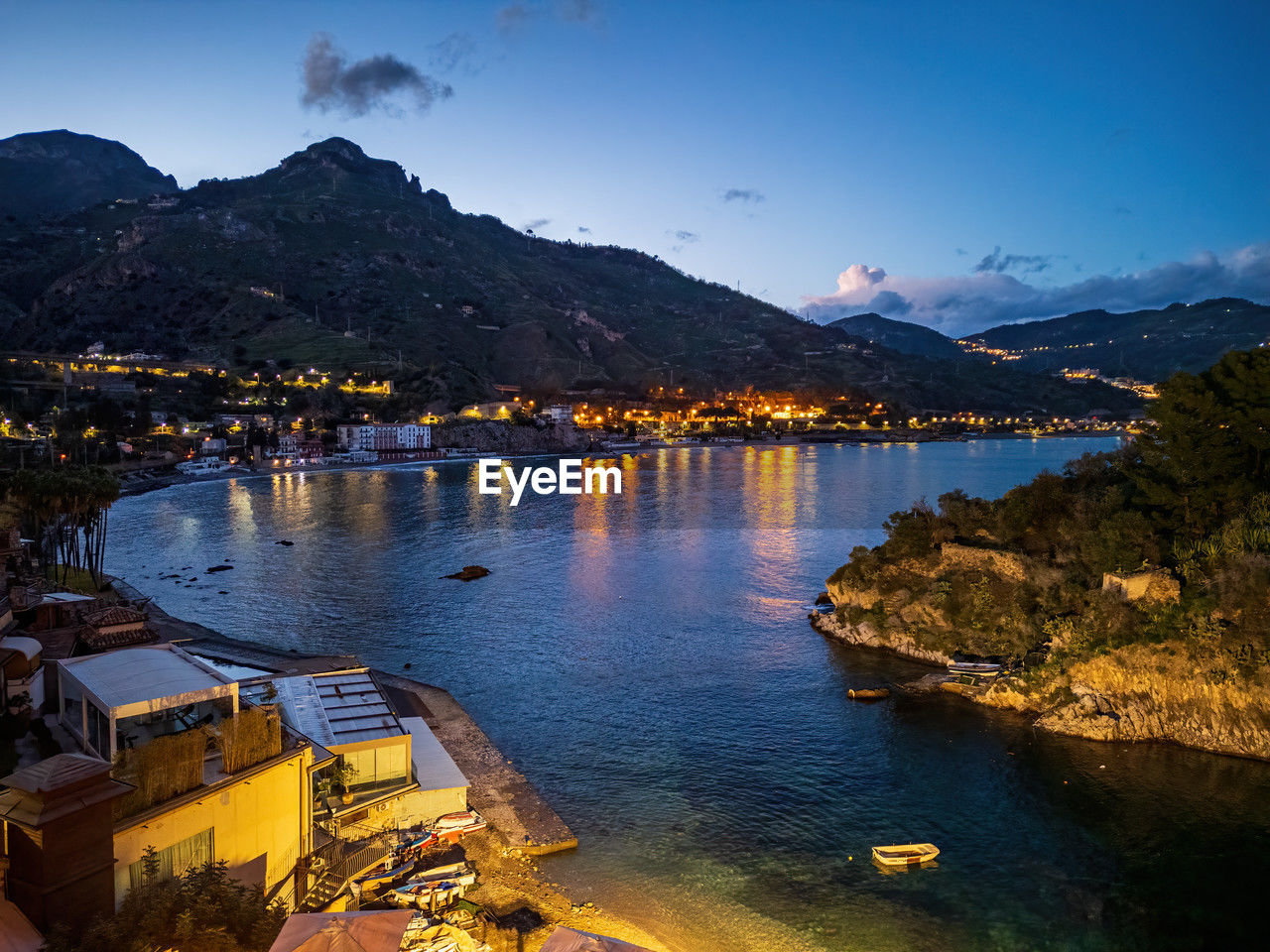 Aerial view of taormina's coastline at dusk - serene with light reflections
