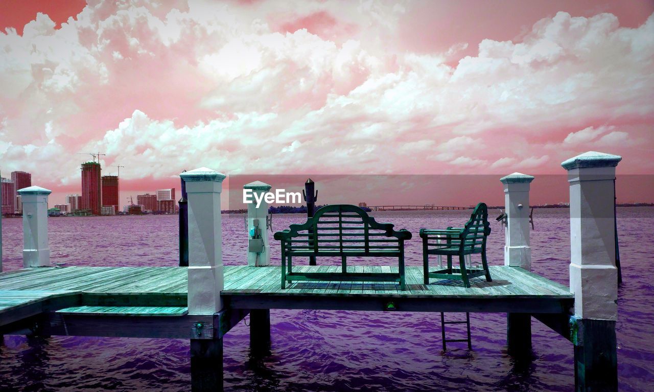 EMPTY BENCHES BY SEA AGAINST SKY