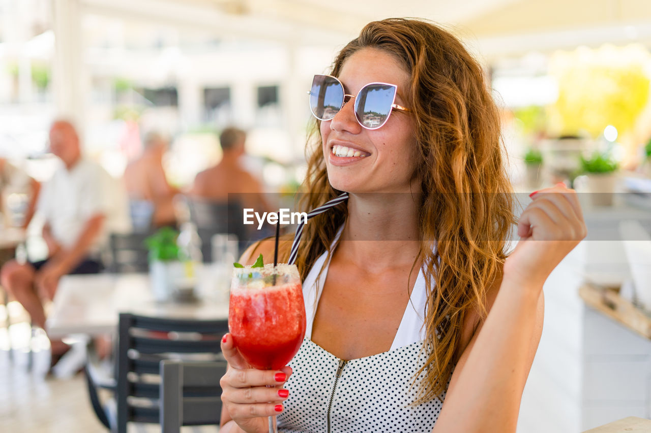 Woman holding juice in restaurant