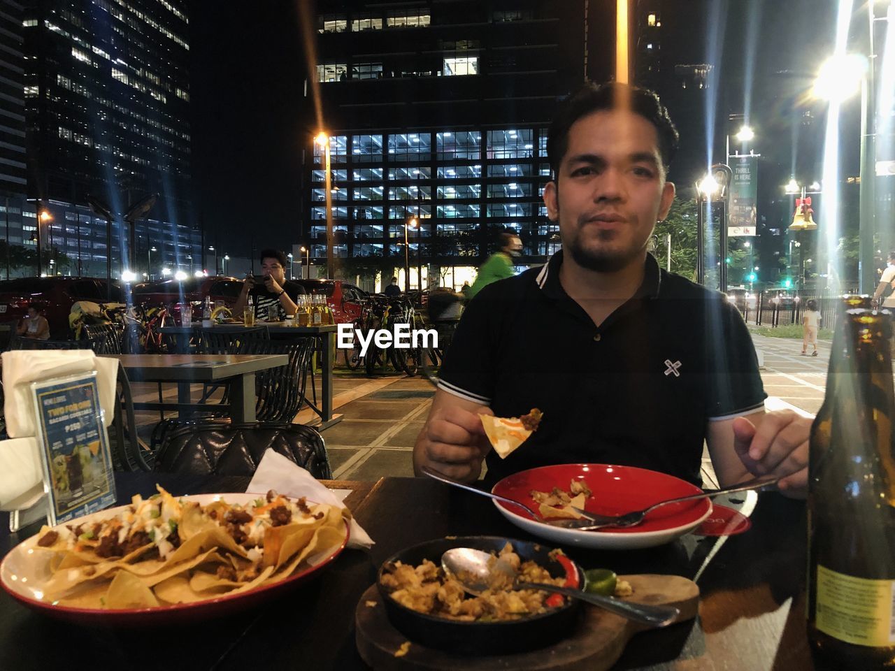 food and drink, food, fast food, night, business, one person, adult, dish, men, city, portrait, restaurant, looking at camera, occupation, architecture, front view, illuminated, person, waist up, clothing, freshness, cuisine, city life, meal