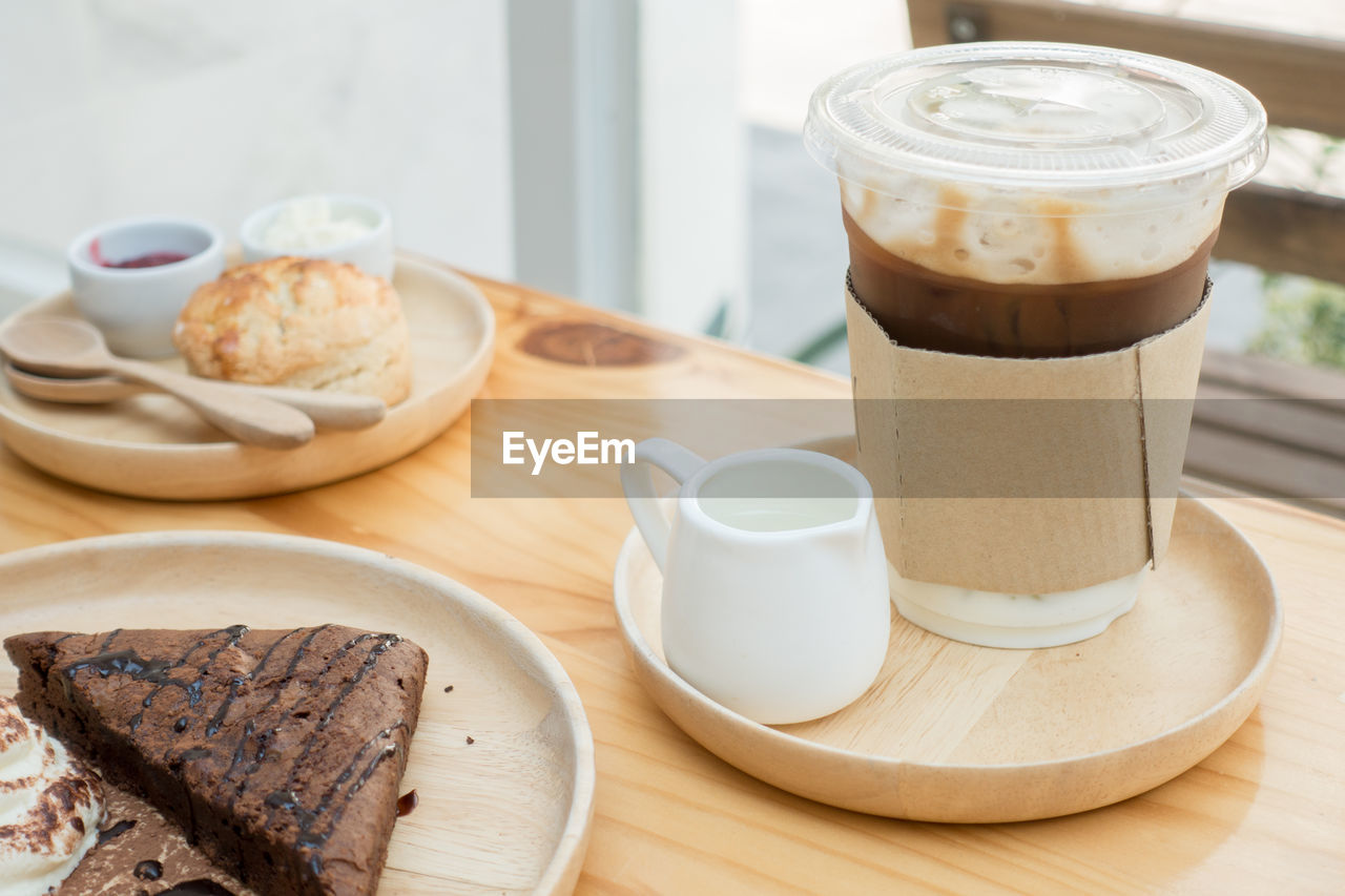 High angle view disposable coffee cup with cake in tray