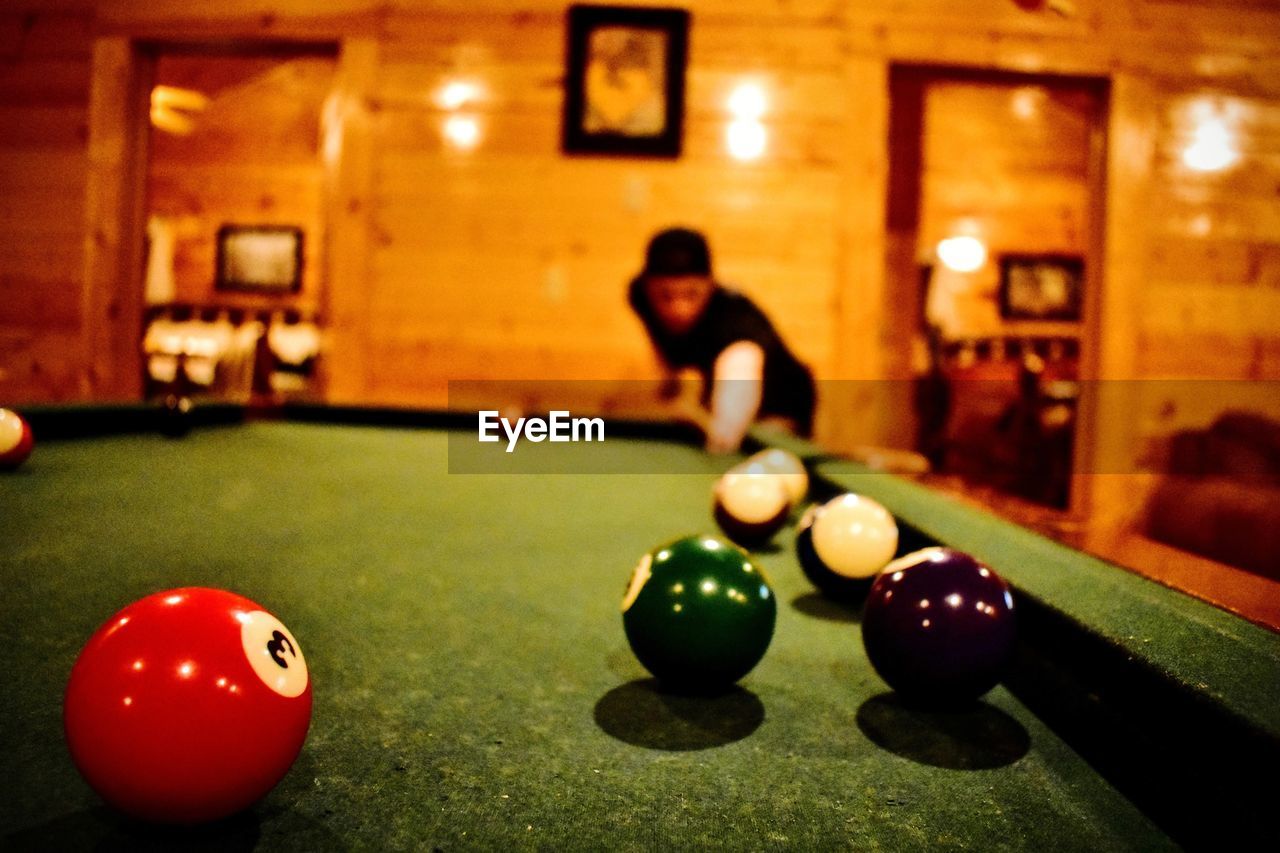 MAN AND BALL ON TABLE AT ILLUMINATED KITCHEN