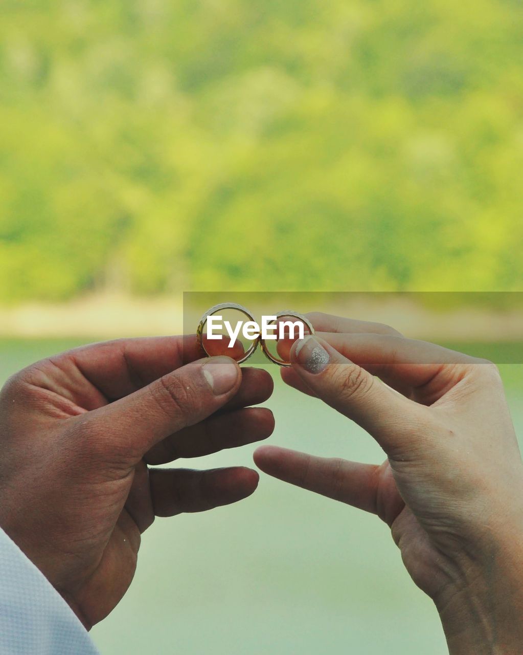 cropped hand of person holding heart shape against sky