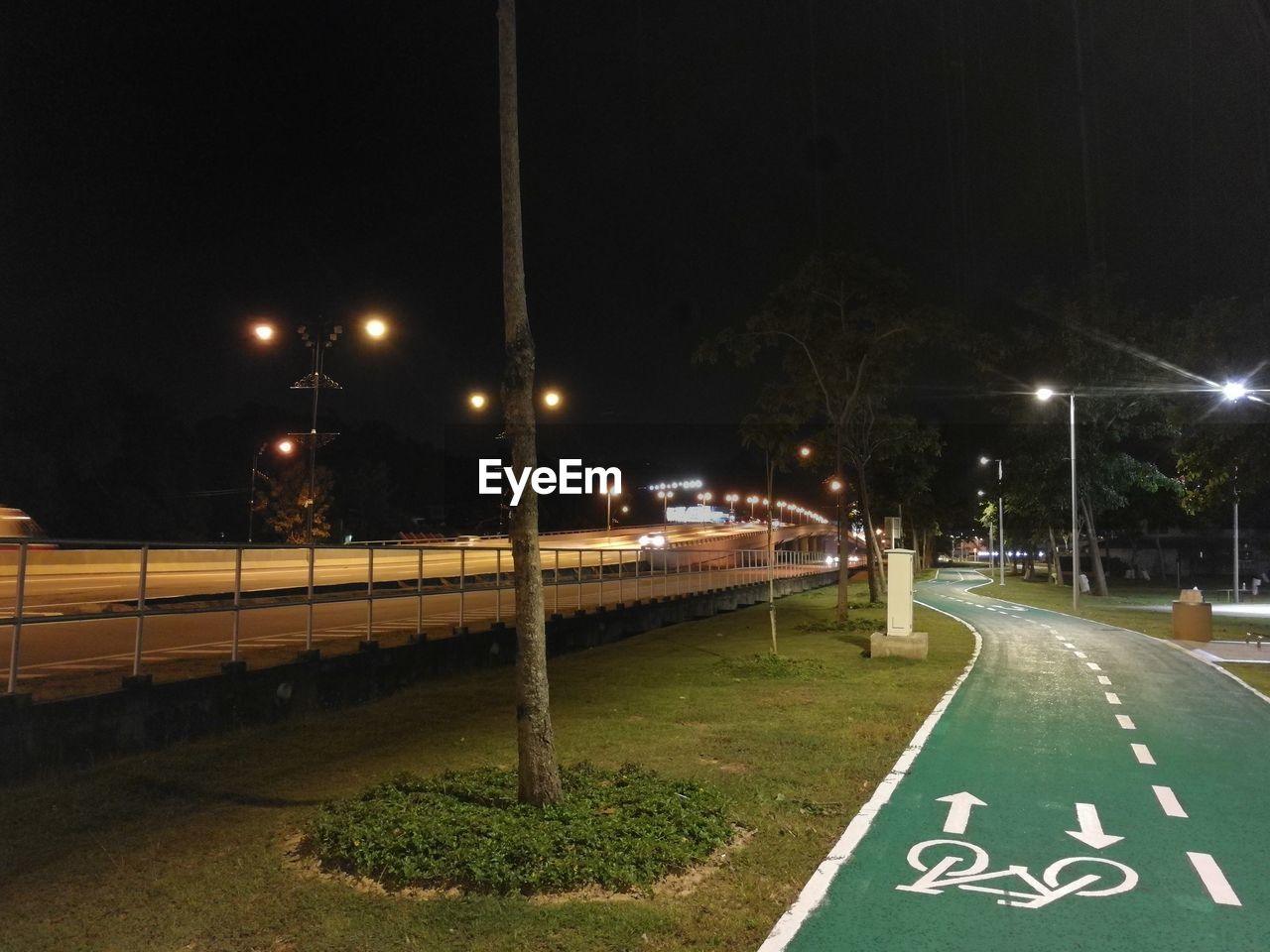 Illuminated road against sky at night