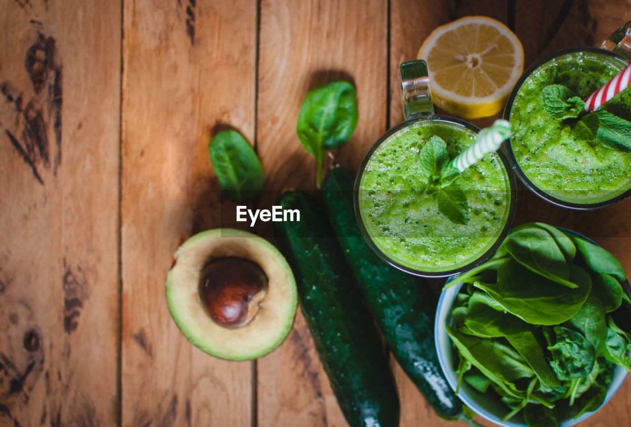 Close-up of green smoothie in a glass with fresh mint and ingredients, top view