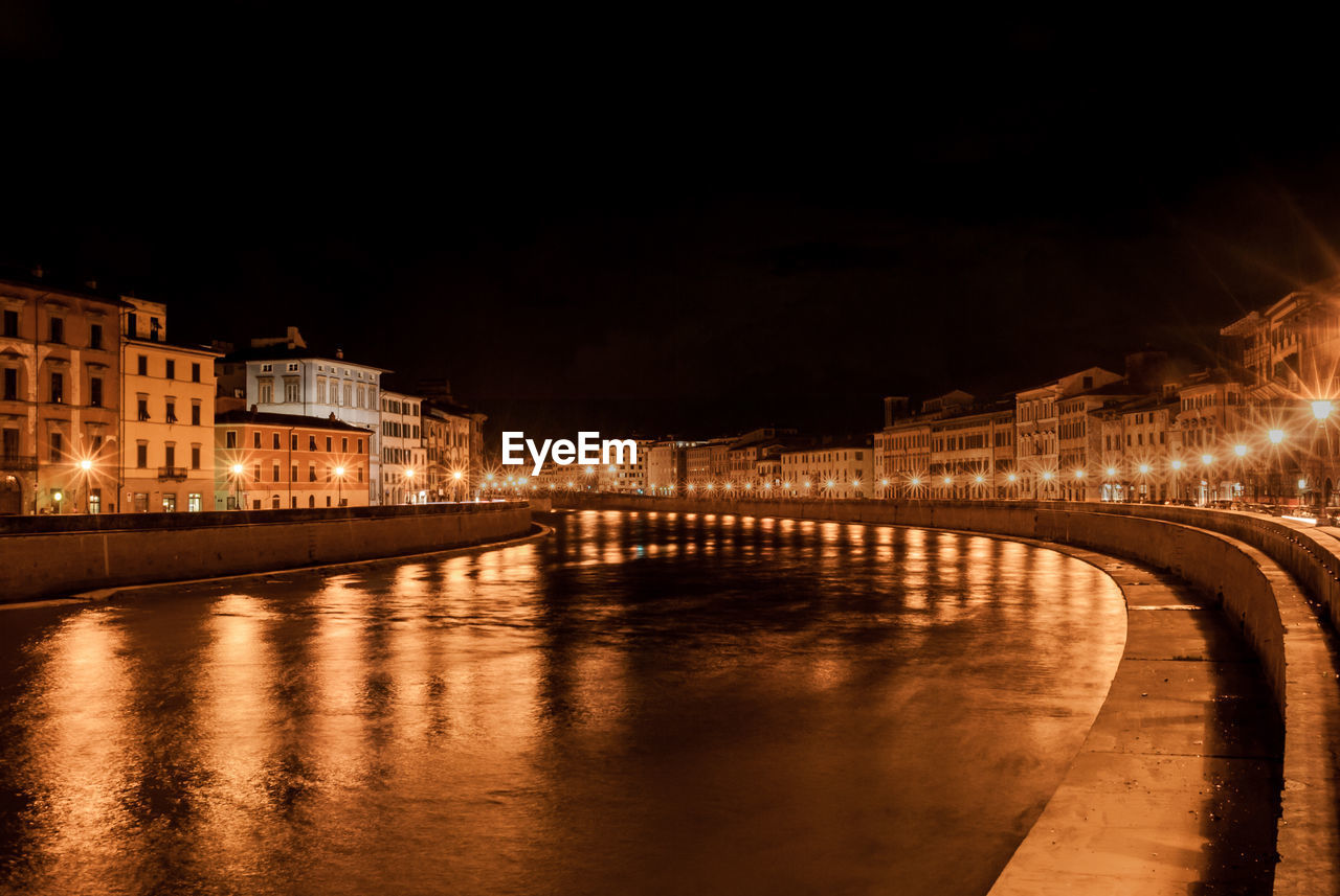 Canal passing through city at night