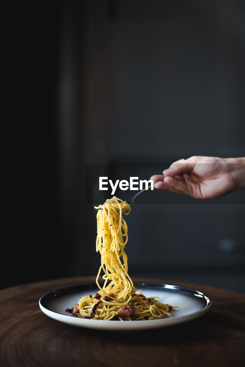 Noodles in fork held by person