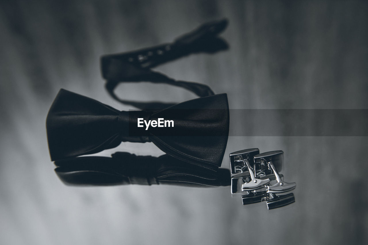 High angle view of bow tie and cuff link on table