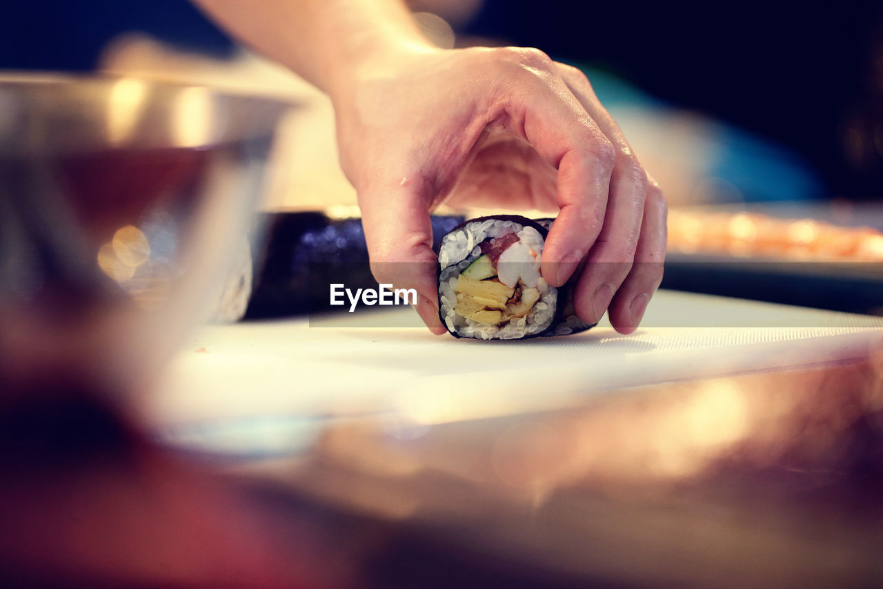 Cropped image of chef preparing sushi in restaurant