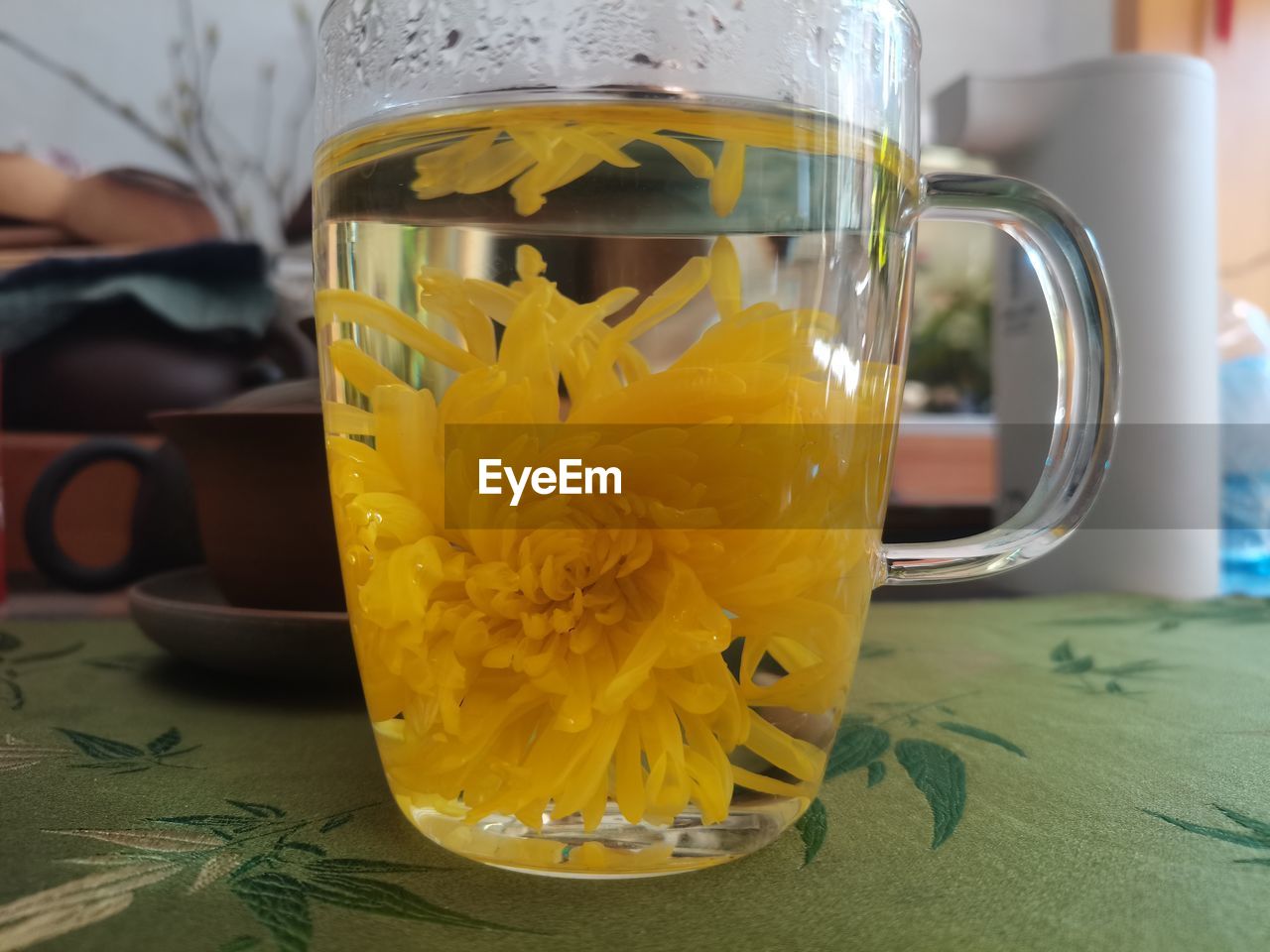 yellow, food and drink, drink, mug, indoors, refreshment, table, tea, close-up, cup, freshness, glass, hot drink, drinkware, focus on foreground, still life, drinking glass, tea cup, no people, jar, household equipment, food, pitcher - jug, flower, container
