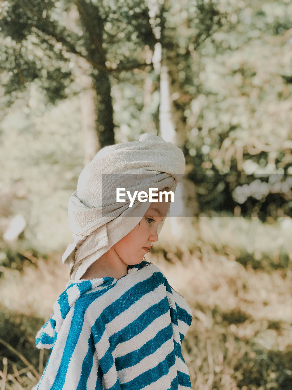 Side view of thoughtful girl standing on field 