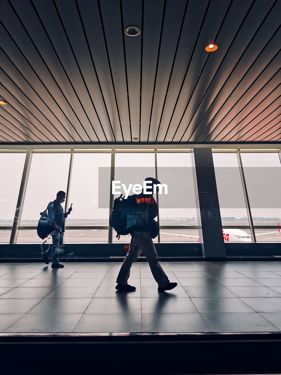 Rear view of men walking in airport