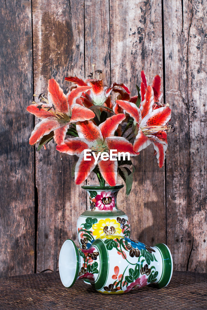 Still life with flowers and ancient ceramic vase.