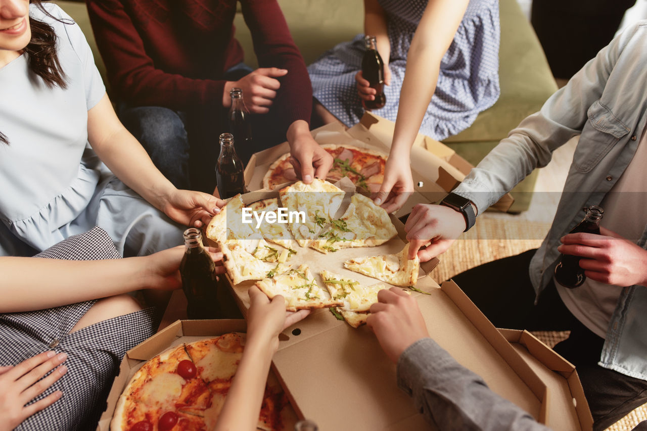 Pizza party, group of friends eating pizza, drinking sweet soda water. birthday celebration