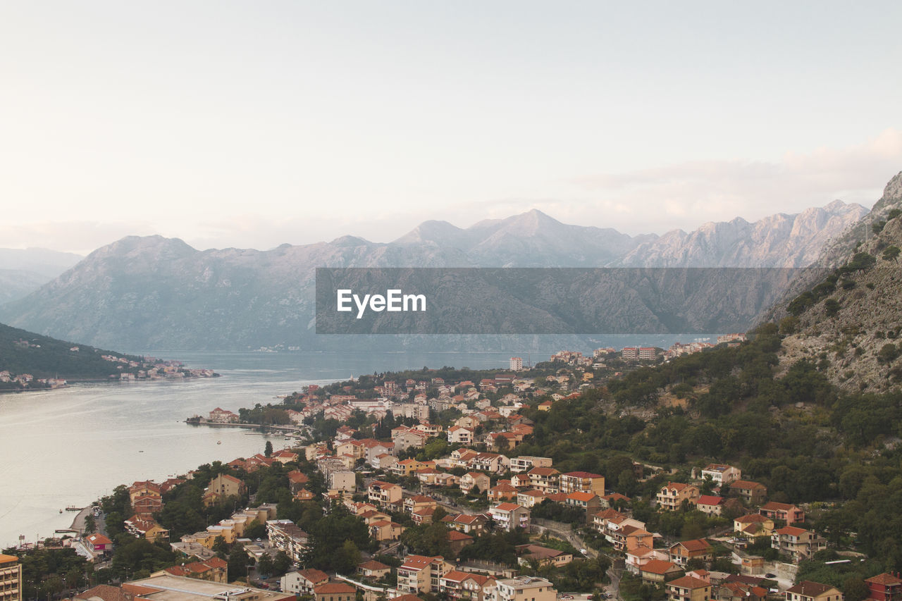 Aerial view of townscape and mountains against sky