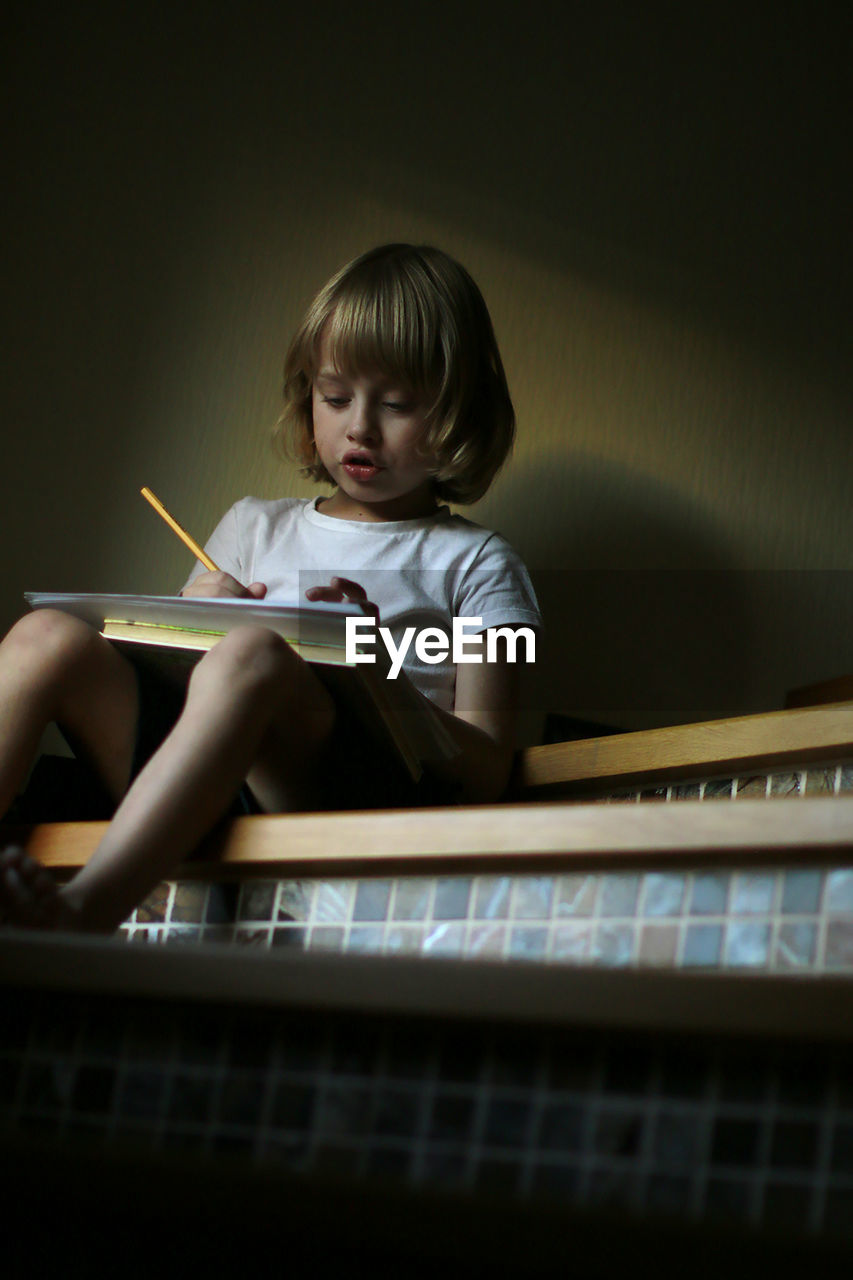 FULL LENGTH OF A BOY HOLDING PAPER