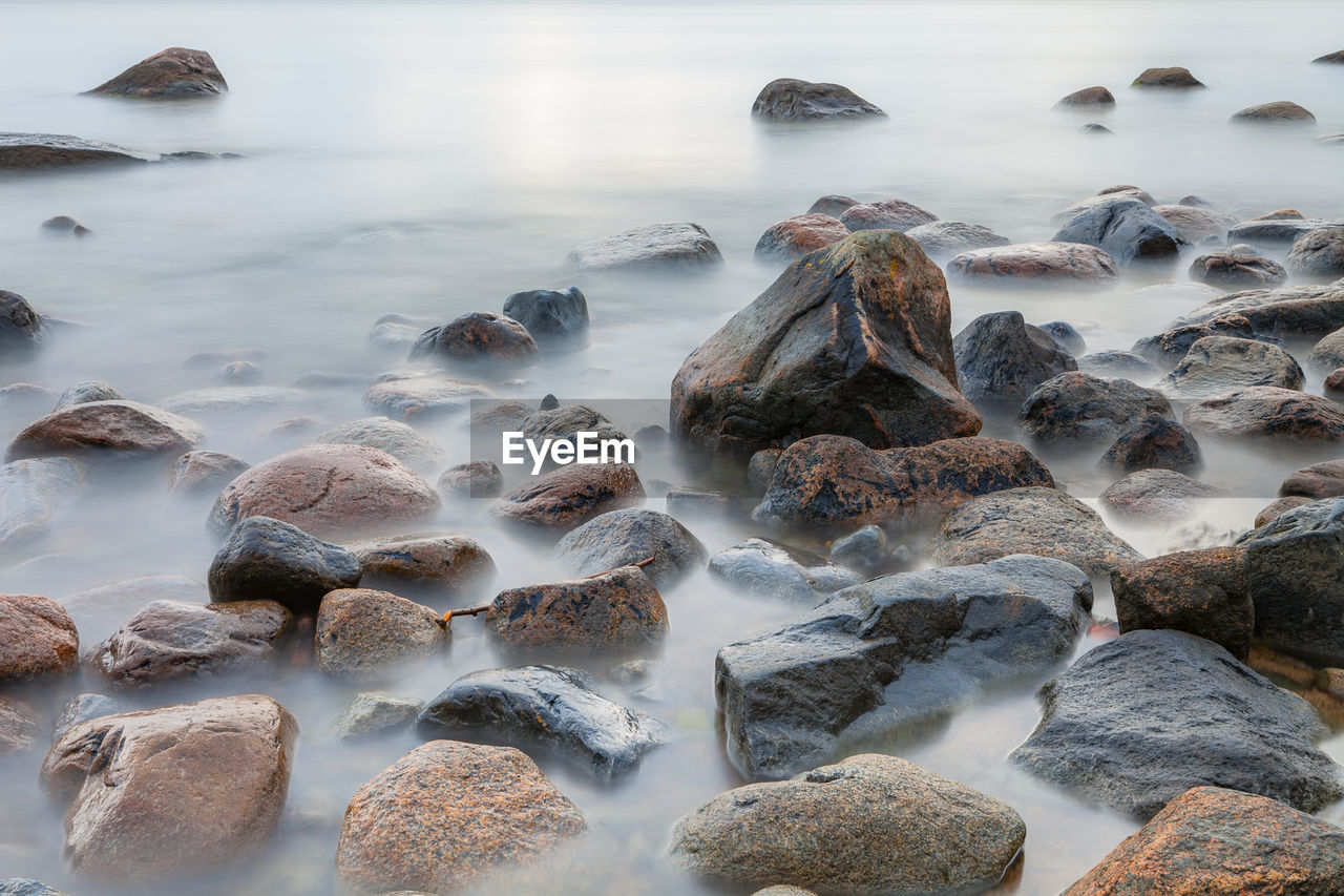 Panoramic shot of pebbles on beach against sky