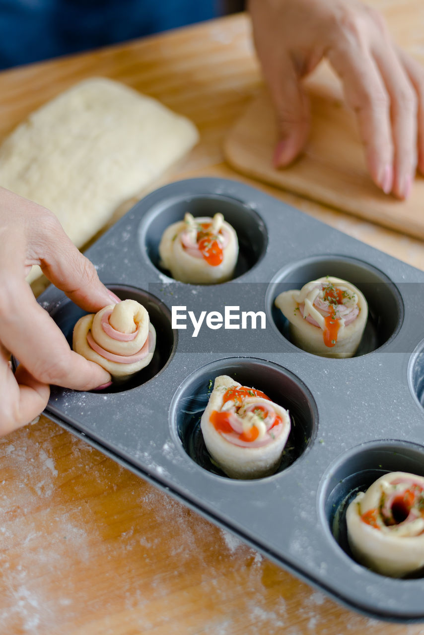 Cropped hands of woman preparing food in baking tray