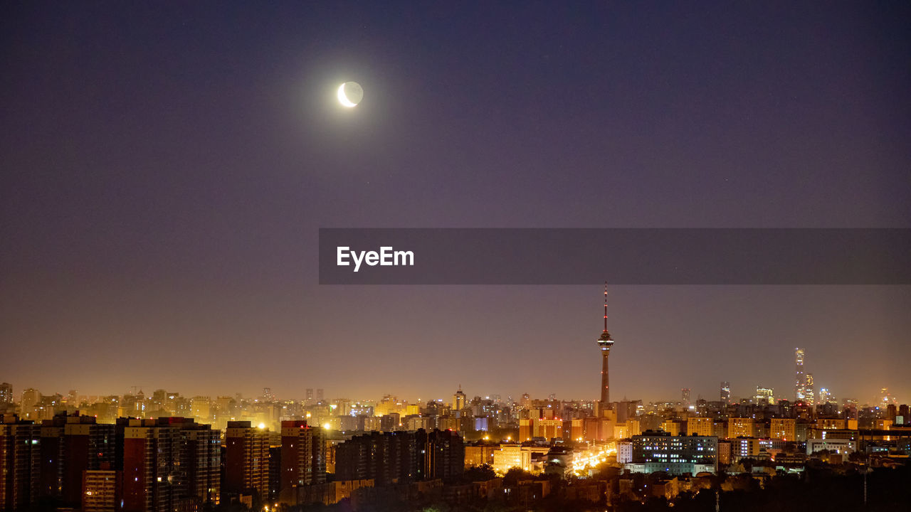 architecture, building exterior, city, night, moon, sky, built structure, cityscape, building, horizon, skyline, evening, illuminated, dusk, urban skyline, landscape, nature, skyscraper, office building exterior, no people, travel destinations, city life, residential district, full moon, outdoors, astronomical object, tower, panoramic