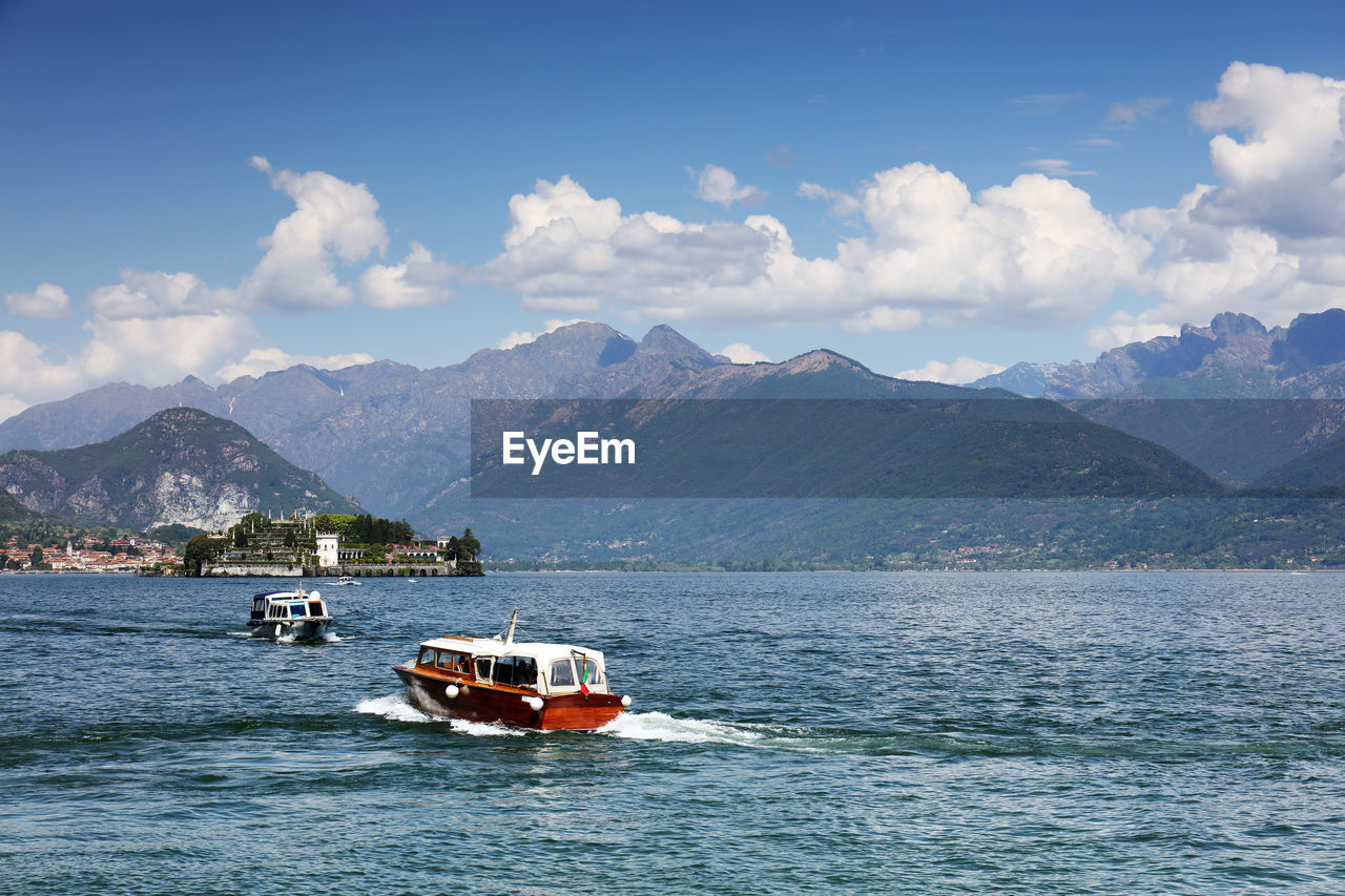 SCENIC VIEW OF SEA AGAINST MOUNTAIN RANGE