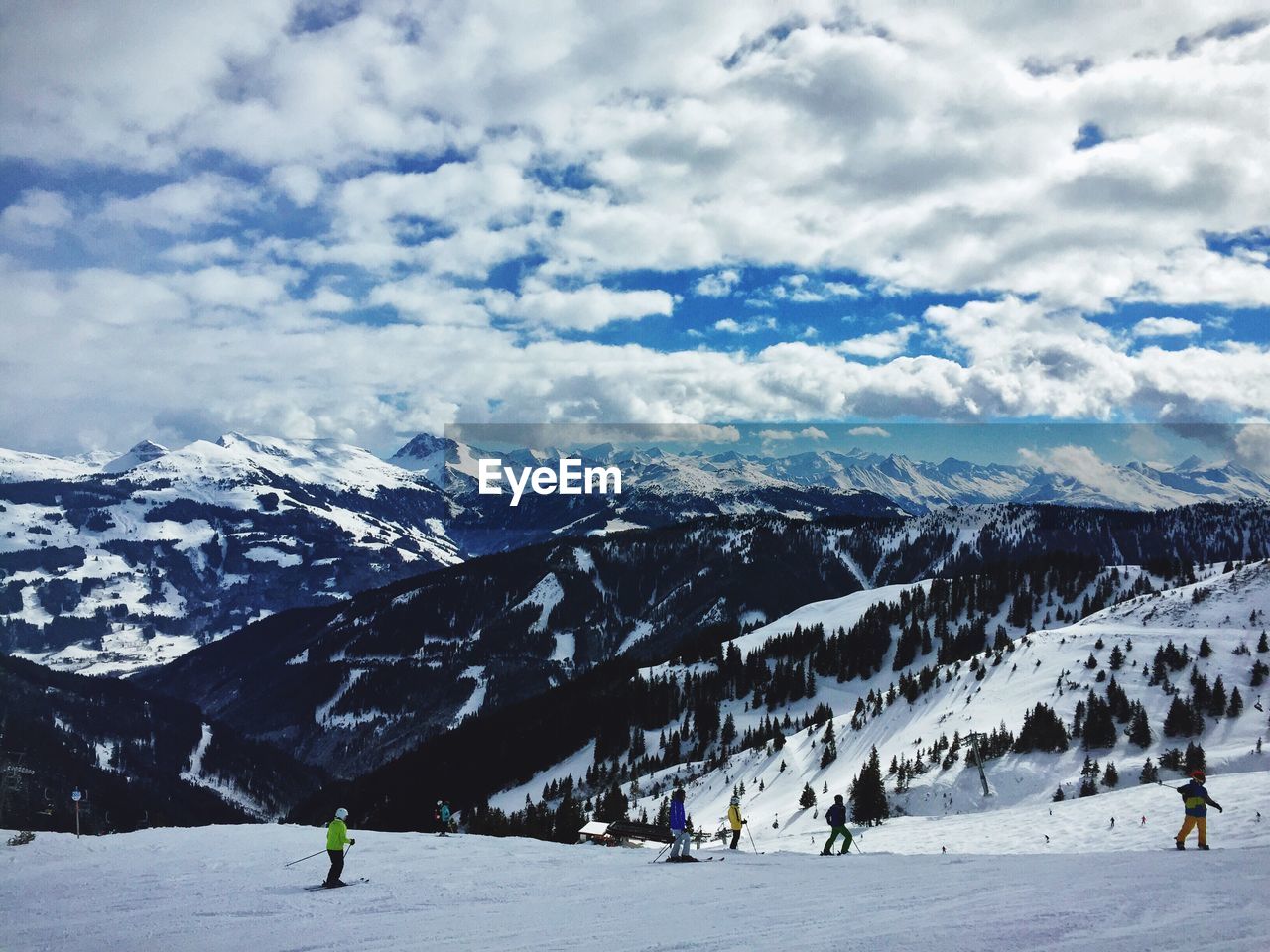 People skiing on snow against mountains