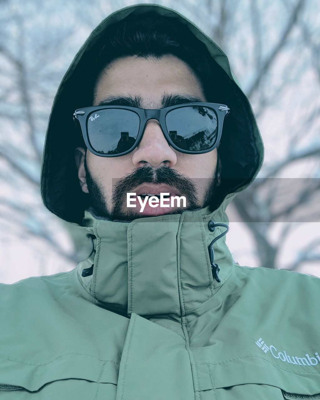 CLOSE-UP PORTRAIT OF YOUNG MAN WITH SNOW IN PARK