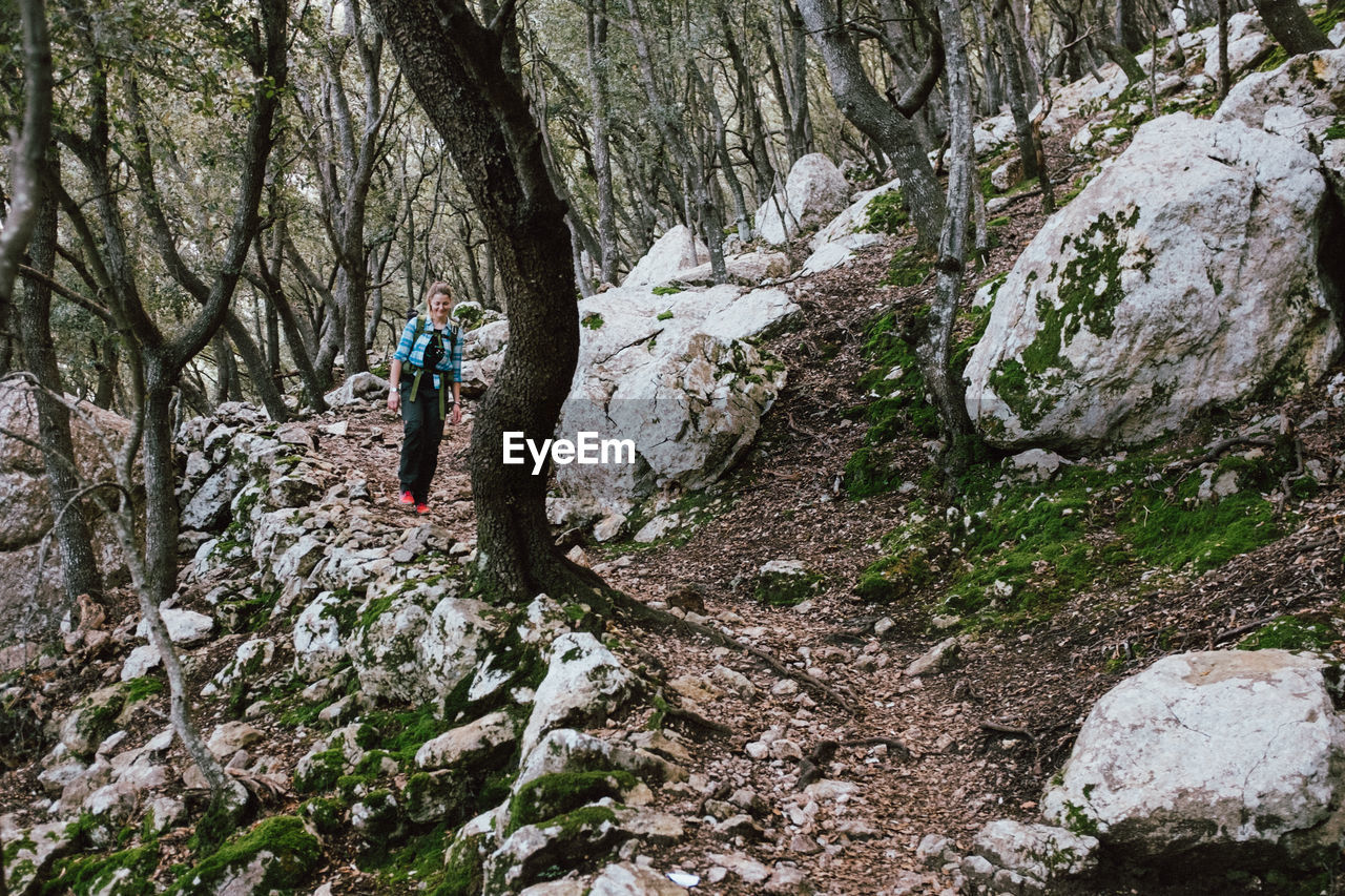 Woman walking by trees in forest