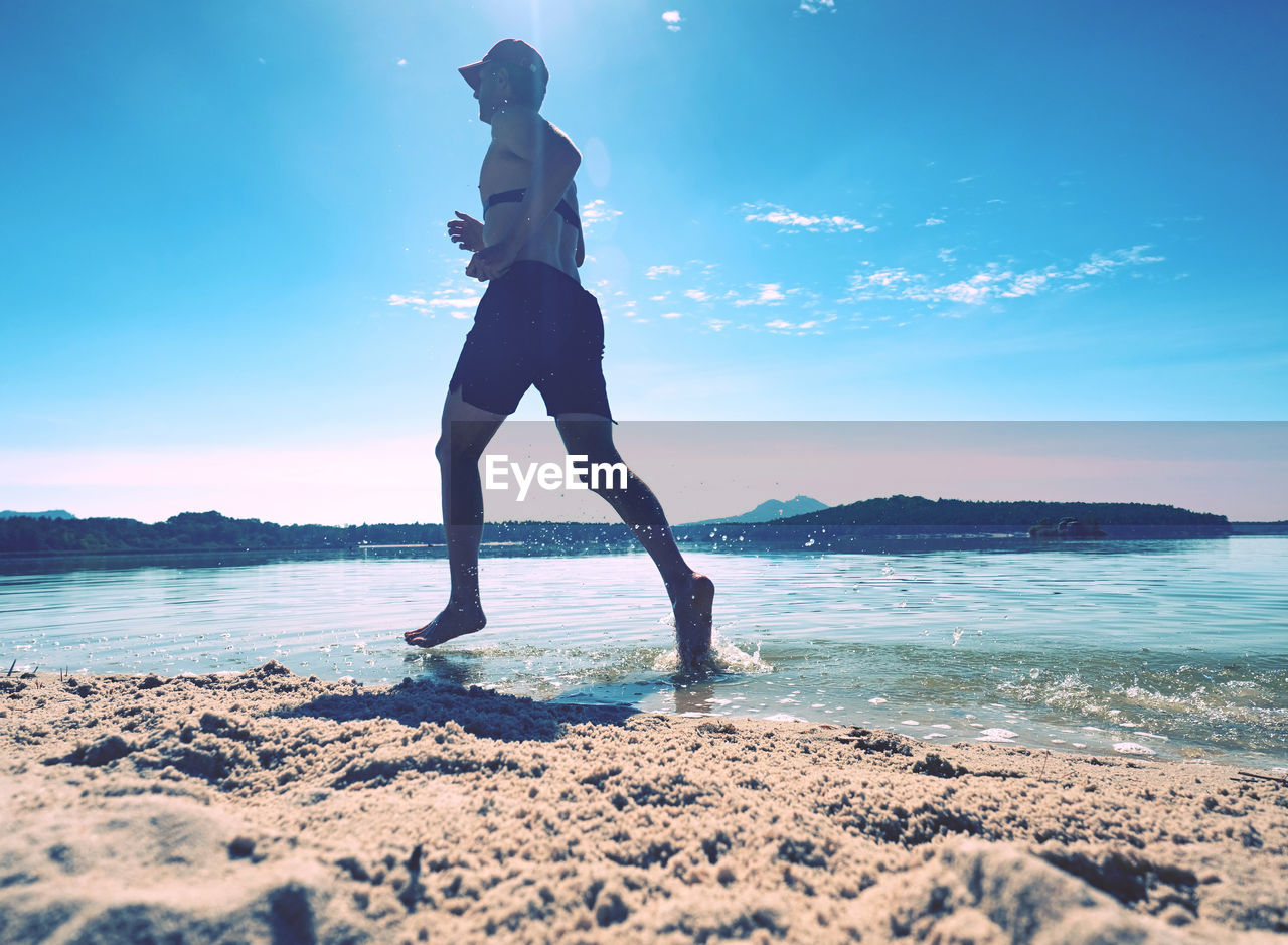 sea, water, sky, one person, adult, land, ocean, nature, blue, beach, full length, sports, horizon, wave, lifestyles, exercising, beauty in nature, motion, women, standing, young adult, holiday, vacation, sunlight, leisure activity, trip, scenics - nature, clothing, outdoors, travel, sand, copy space, tranquility, activity, vitality, coast, environment, relaxation, men