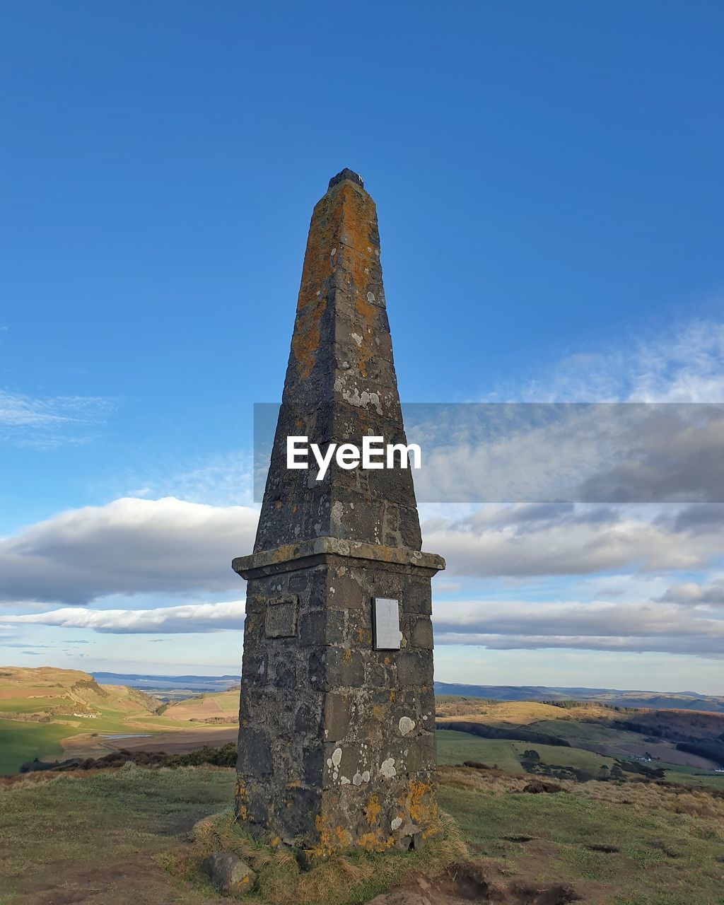 Low angle view of obelisk against cloudy sky