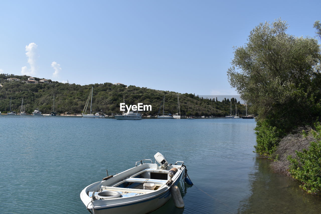 Boats in sea against clear sky