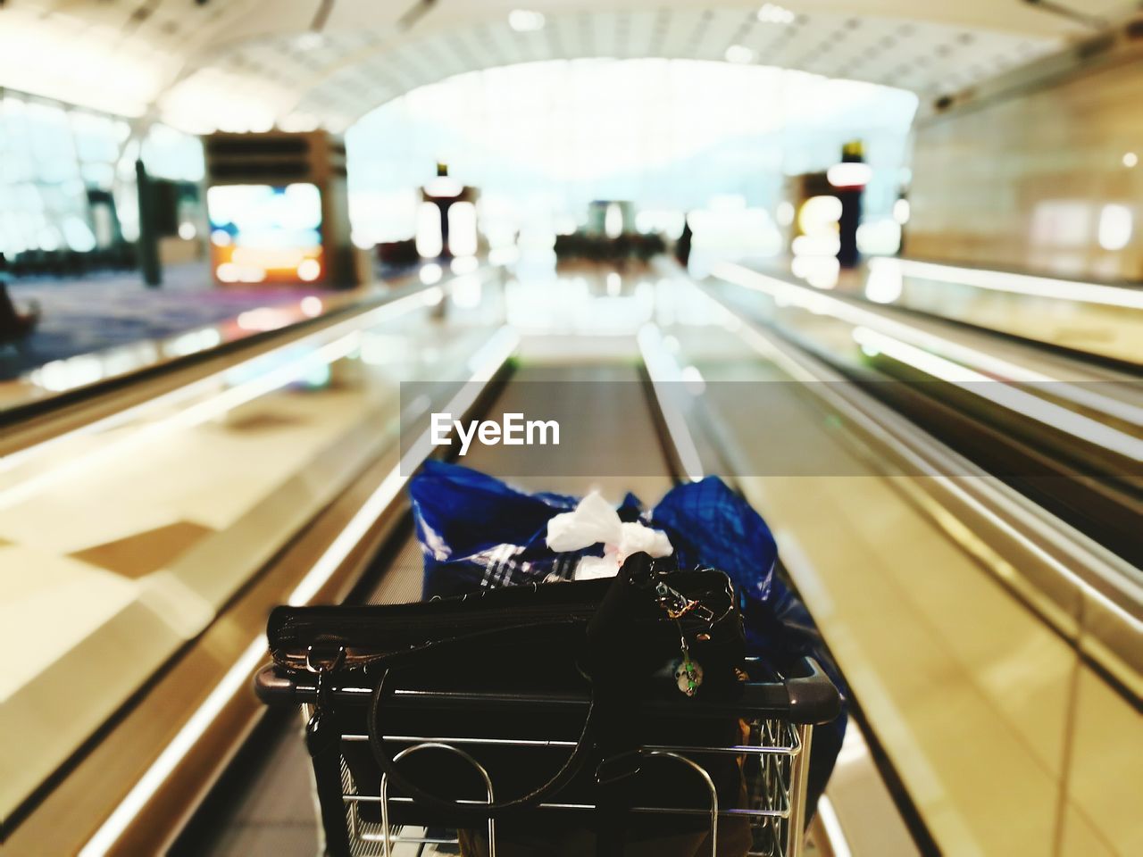 High angle view of bags in shopping cart on escalator
