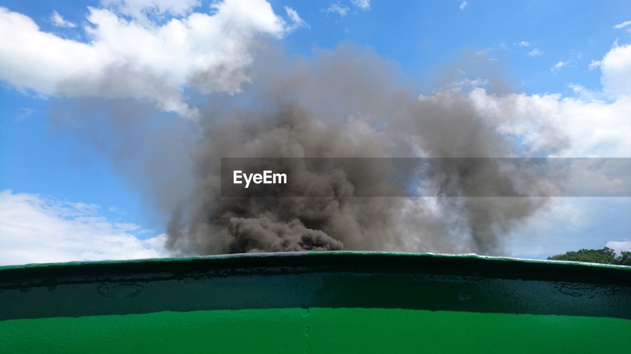 Low angle view of smoke emitting from train against sky on sunny day