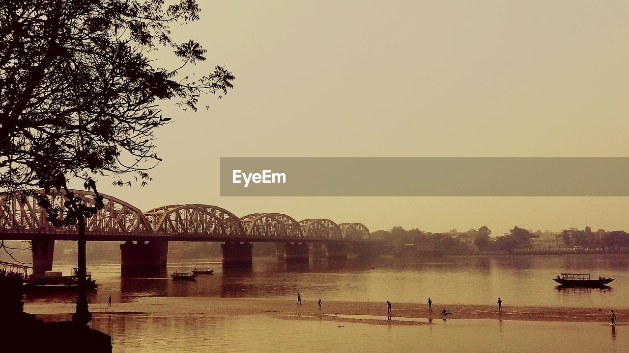 Scenic view of river against clear sky at sunset