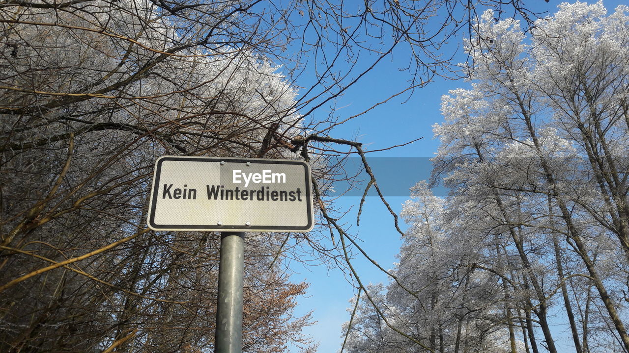 Low angle view of road sign against sky