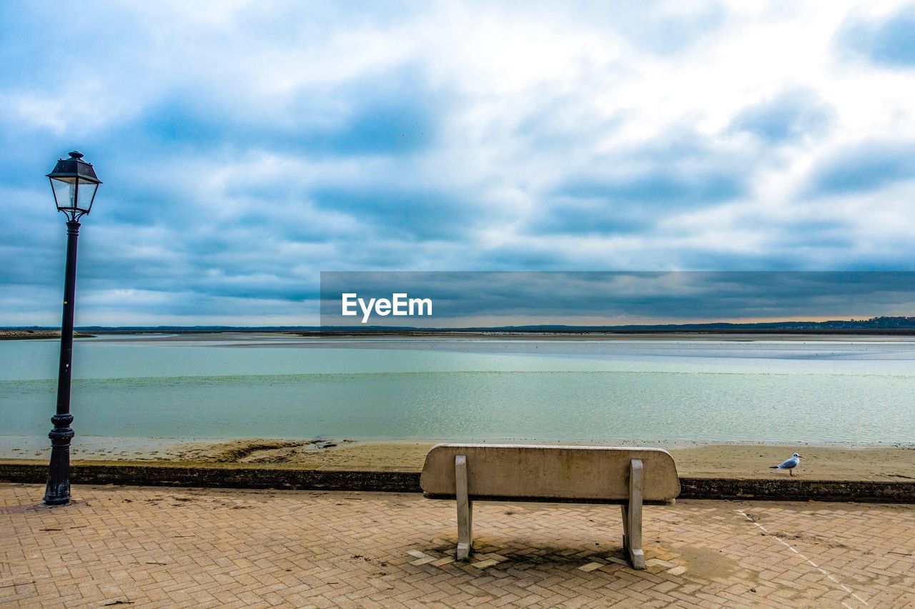 EMPTY CHAIR ON SHORE AGAINST SEA