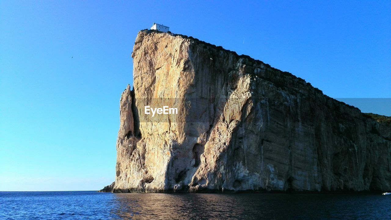 Low angle view of sea against clear blue sky