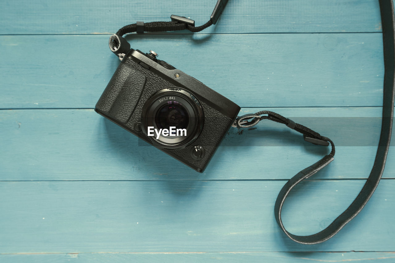 HIGH ANGLE VIEW OF CAMERA ON TABLE AT HOME