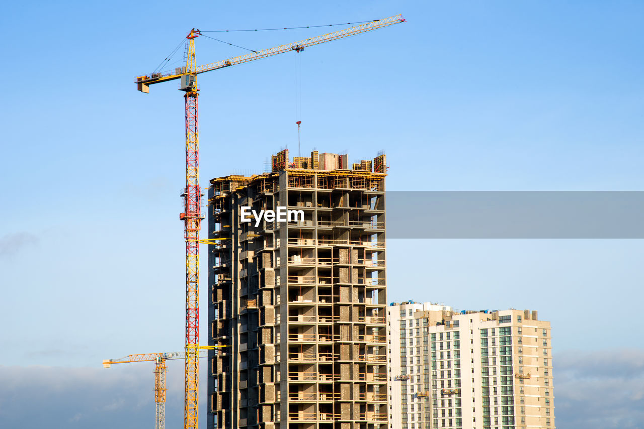 LOW ANGLE VIEW OF CRANE AND BUILDING AGAINST SKY