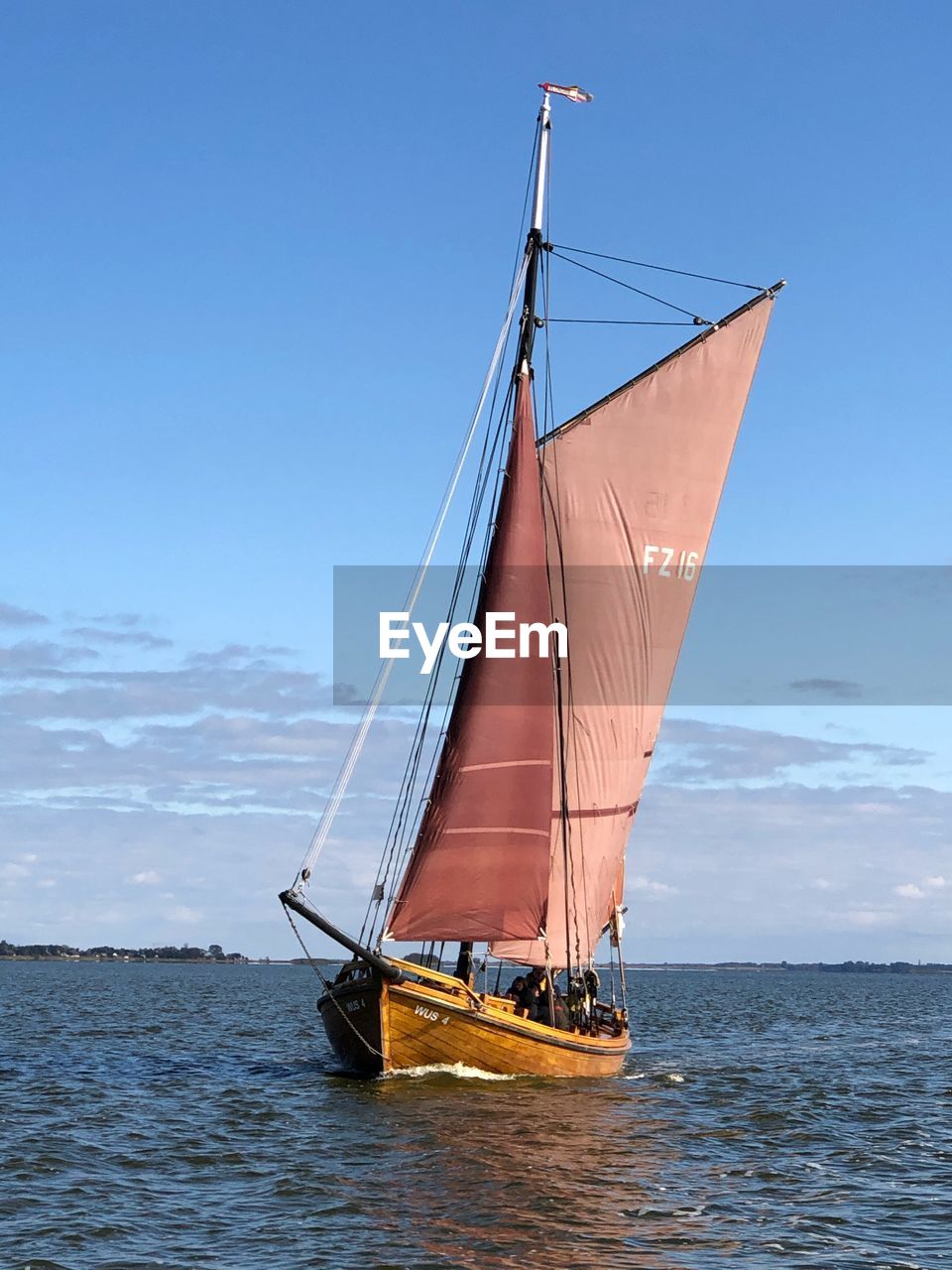 SAILBOAT SAILING IN SEA AGAINST BLUE SKY