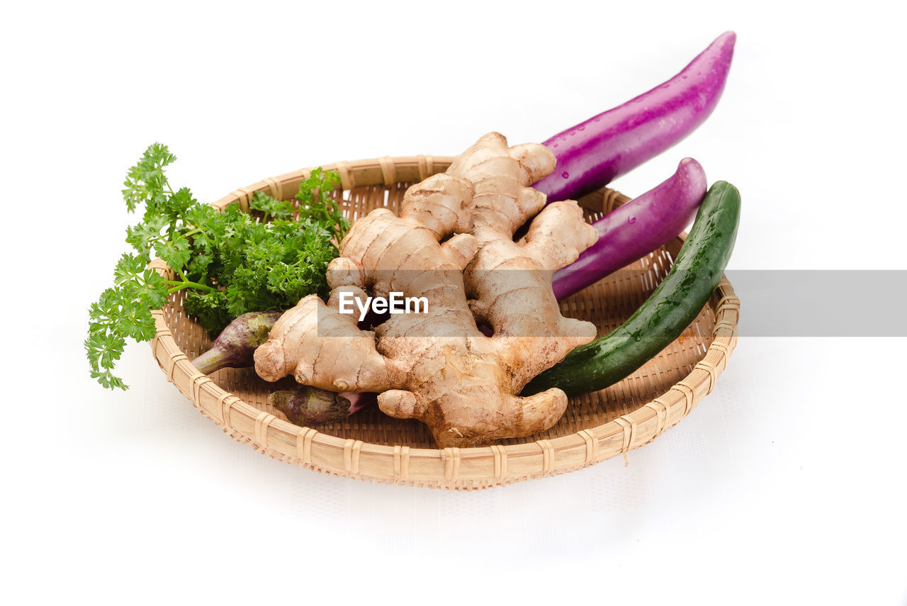 Close-up of food in wicker plate over white background