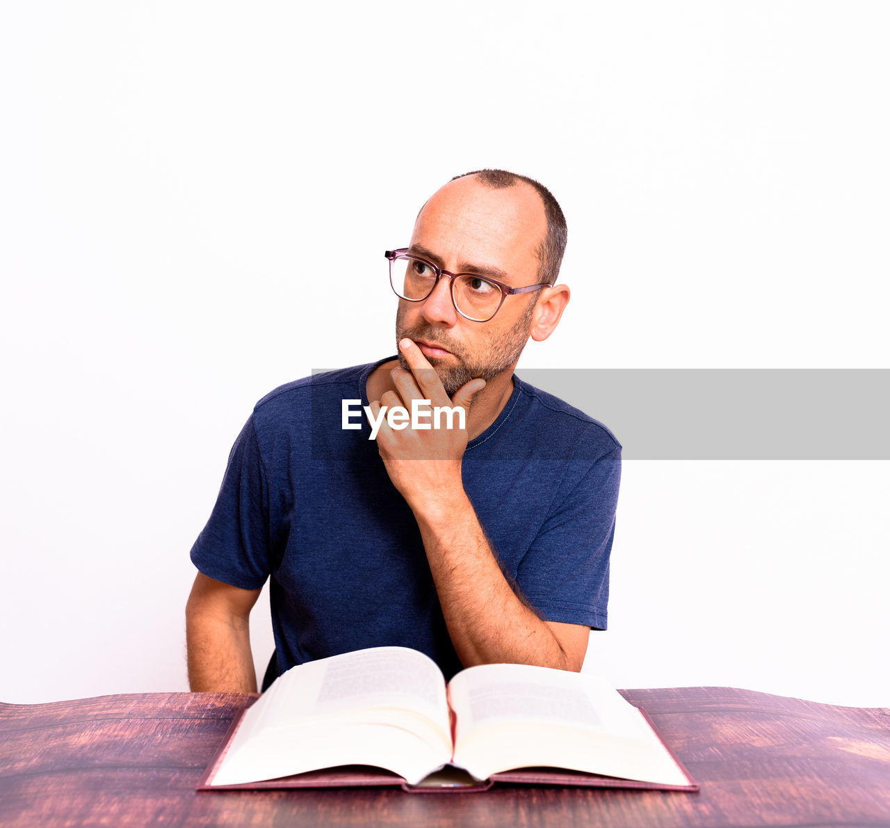 PORTRAIT OF MAN SITTING AGAINST WALL