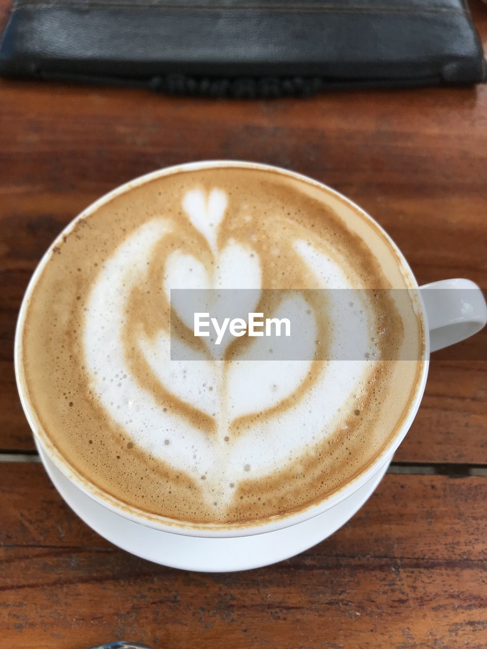 coffee, drink, food and drink, refreshment, coffee cup, frothy drink, cup, mug, cappuccino, hot drink, still life, froth art, wood, table, latte, crockery, food, directly above, indoors, freshness, flat white, creativity, no people, kitchen utensil, saucer, close-up, eating utensil, spoon, brown, high angle view, cafe
