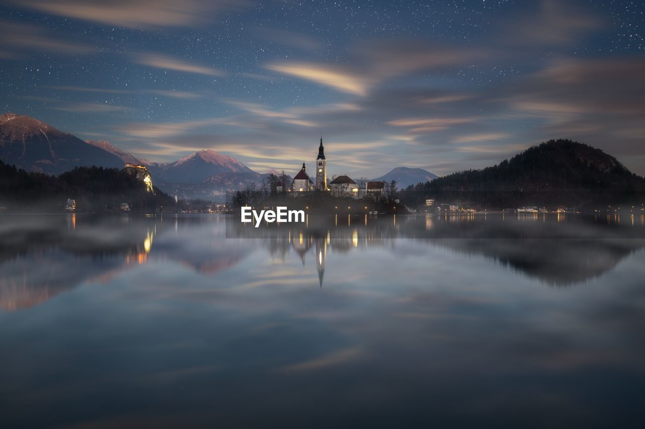 Scenic view of lake by mountains against sky