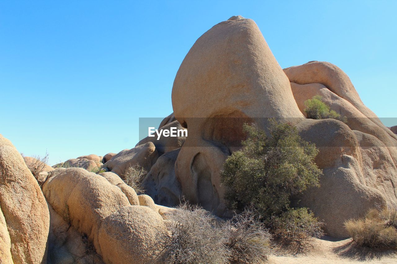 LOW ANGLE VIEW OF STATUE AGAINST ROCKS