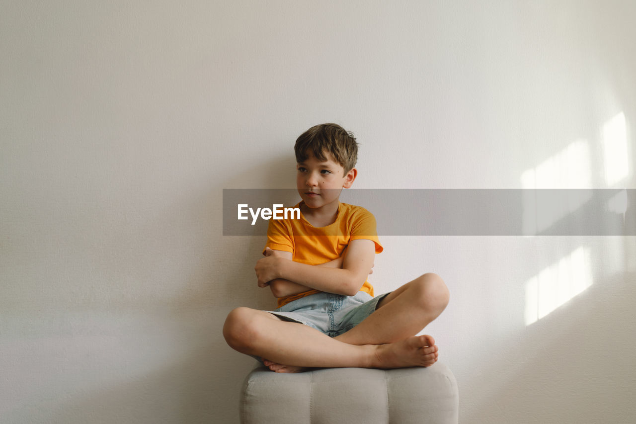 Cute boy sitting barefoot in a home. beautiful light.