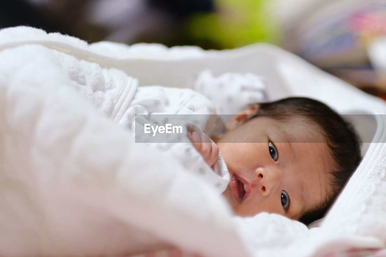 Portrait of cute baby lying on bed