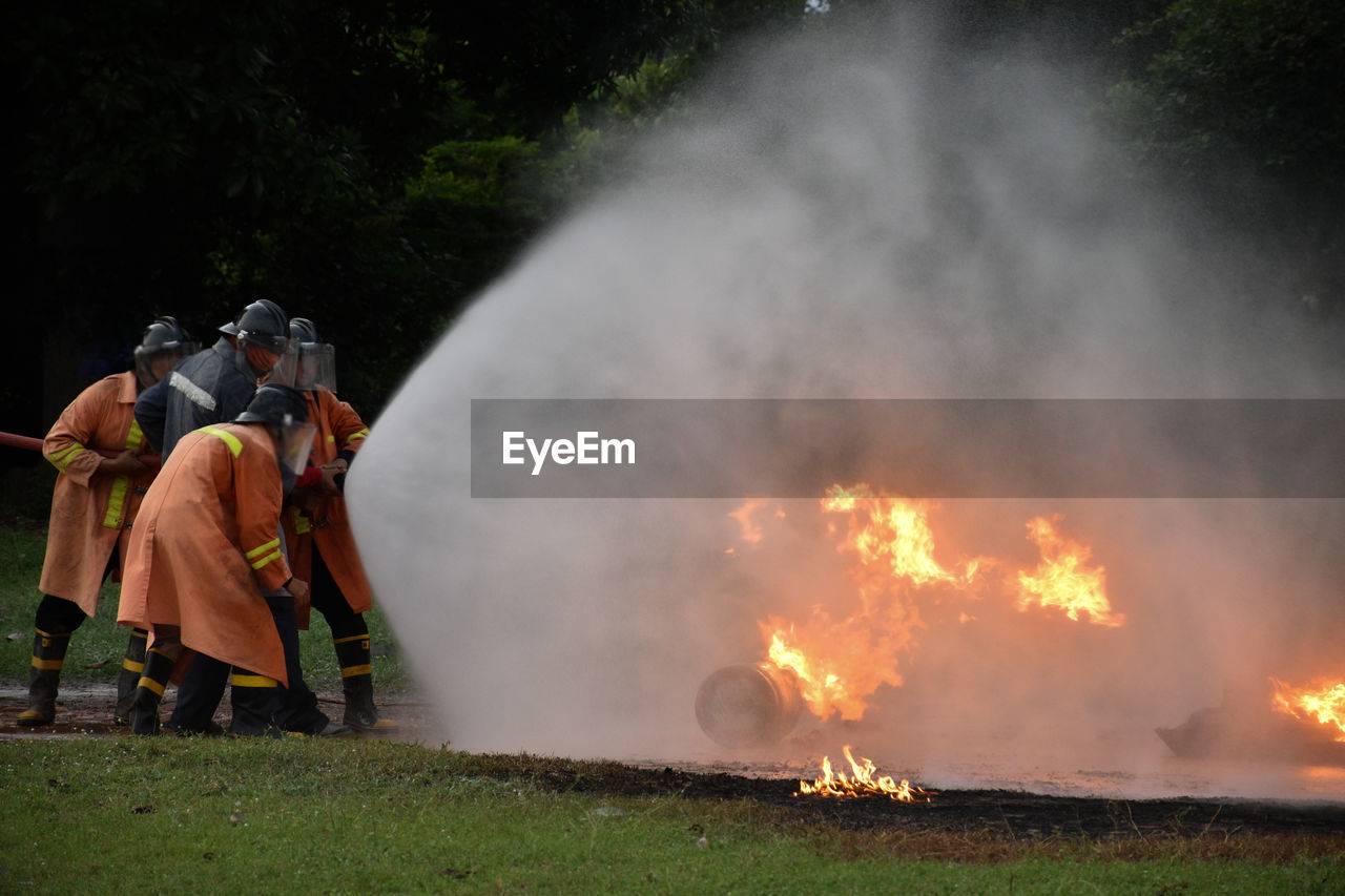 People standing by fire on bonfire