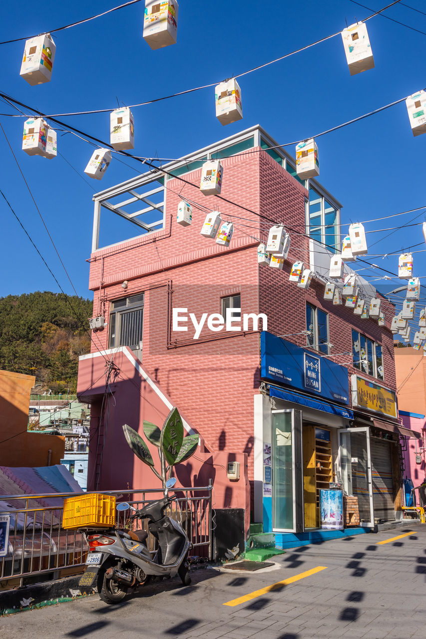 architecture, town, building exterior, city, built structure, neighbourhood, road, transportation, street, residential area, sky, urban area, building, nature, transport, downtown, blue, mode of transportation, day, residential district, clear sky, cable, outdoors, no people, sunny, infrastructure, sunlight, house, travel destinations, suburb